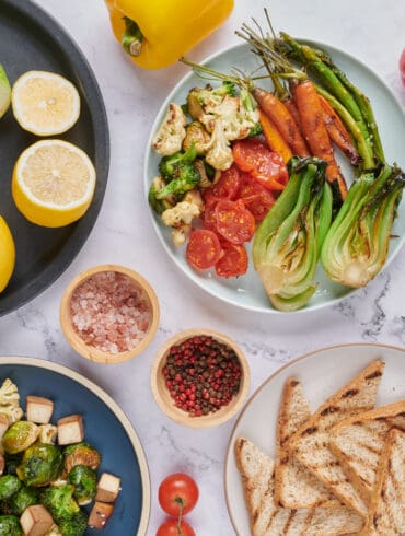 Vegan protein source. Buddha bowl dish, avocado, pepper, tomato, cabbage, chickpea, toast, bread fresh lettuce salad and walnuts, nuts, beans. Healthy vegetarian eating, super food. Top view.
