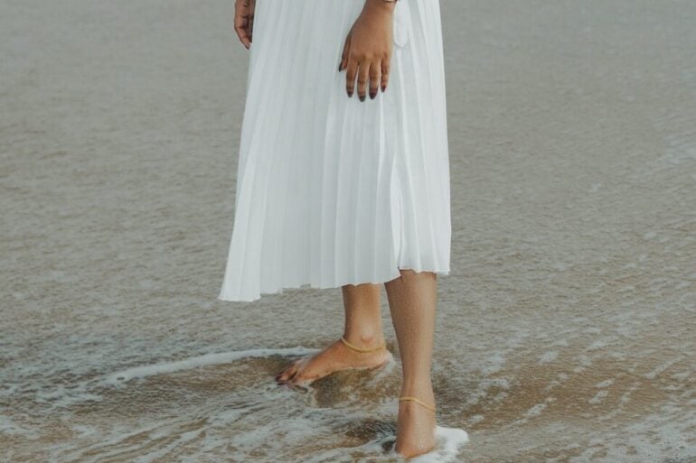 a woman in a white dress standing in the water